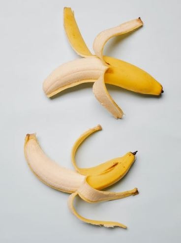 bananas-with-skin-on-white-surface