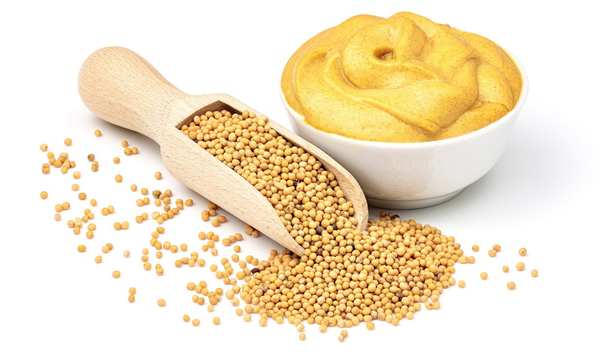 Mustard-seeds-in-the-wooden-scoop-and-mustard-sauce-in-the-bowl-isolated
